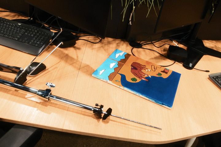 The Carousel painting lying on an office desk beside a mic stand