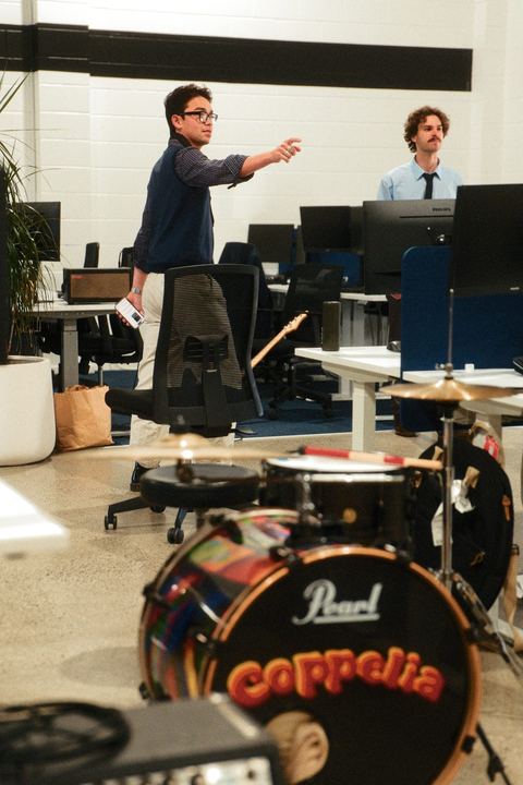 The Coppelia drum kit set up between the desks while the band rehearses